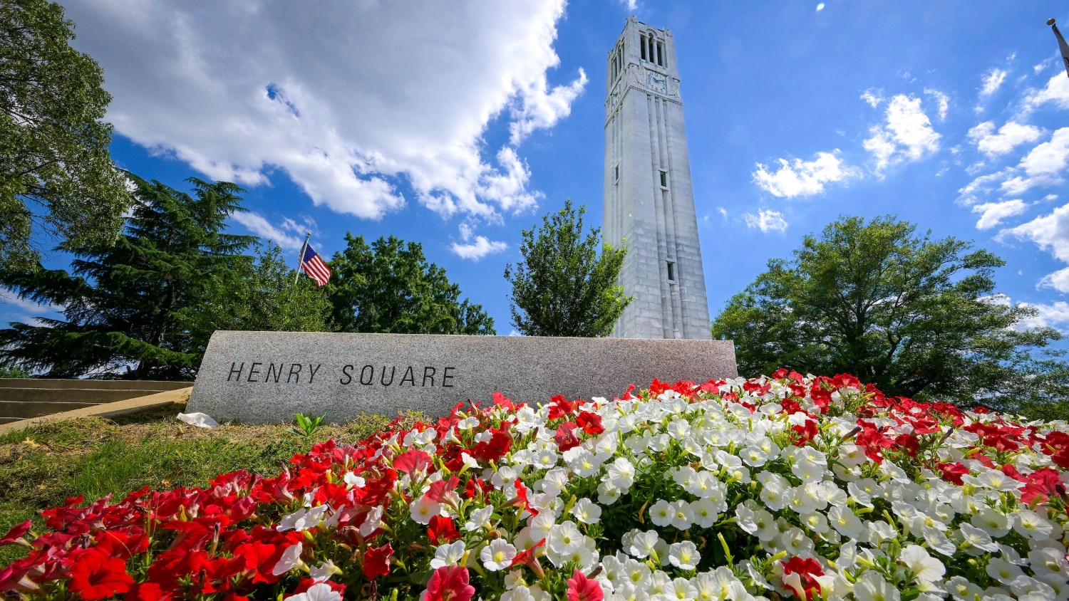 Low angle view of the Belltower at Henry Square surrounded by flowers.