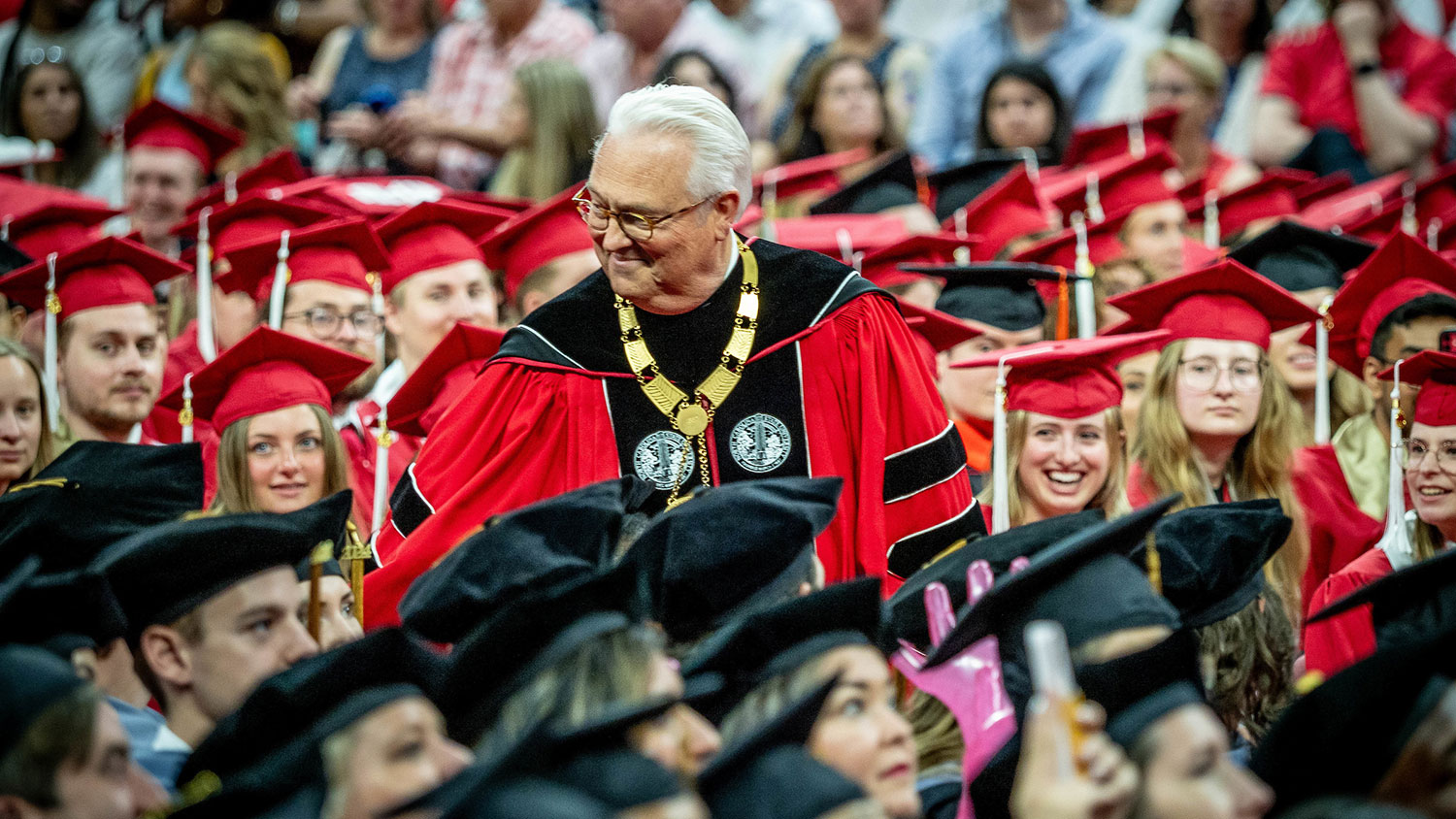 Chancellor Woodson stands in a crowd of graduating students during a commencement ceremony.